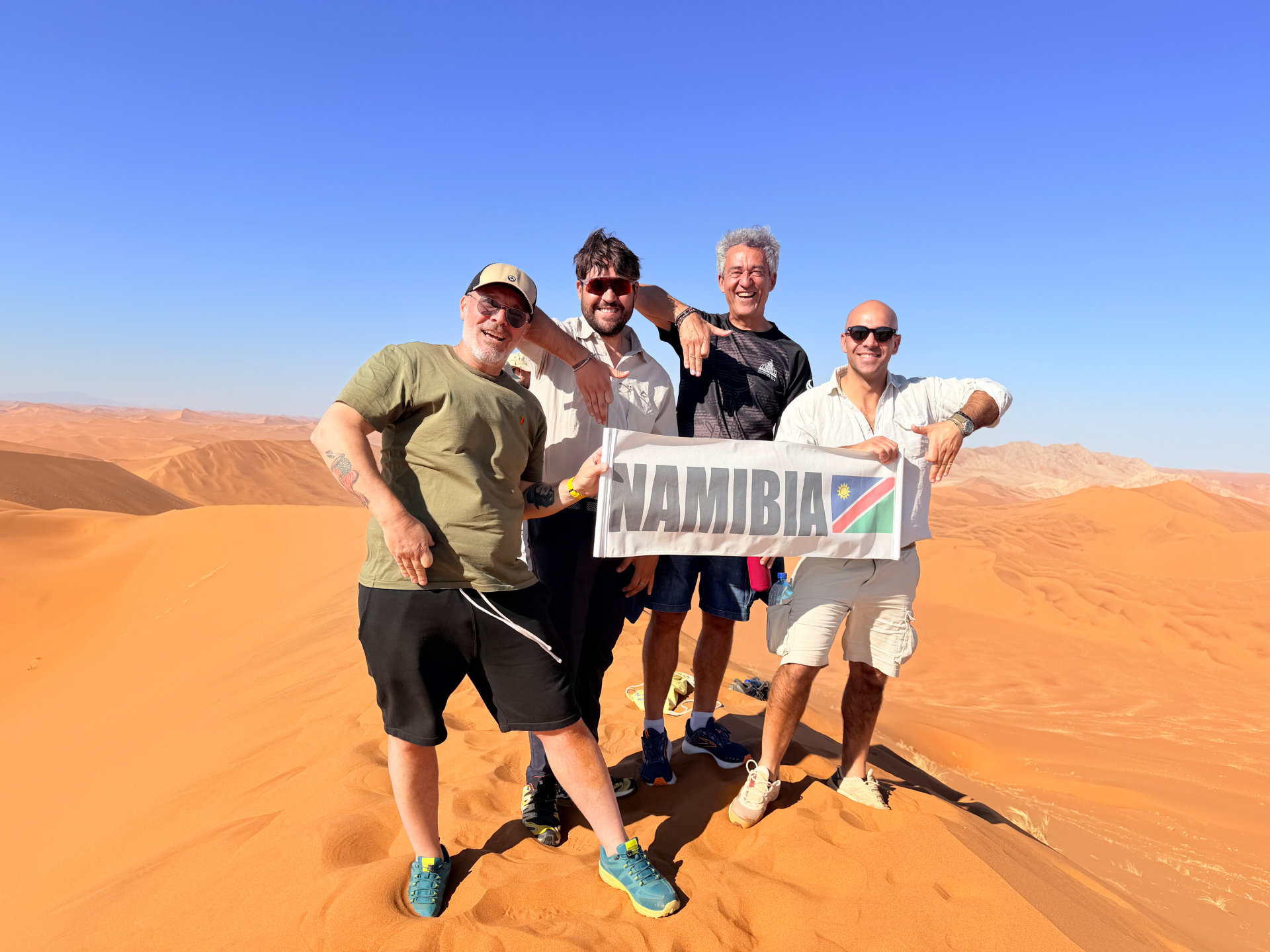 Gruppo Colopolo sulle dune della Namibia con bandiera
